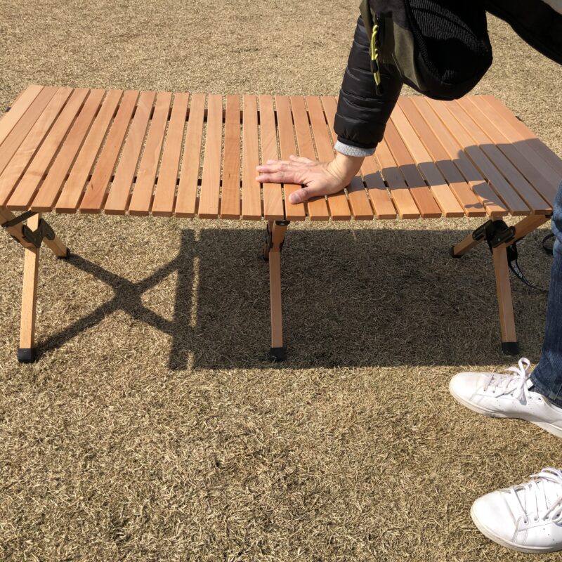 ピースパークフォールディングウッドテーブルの天板を押している画像。天板の強度をあらわしている。